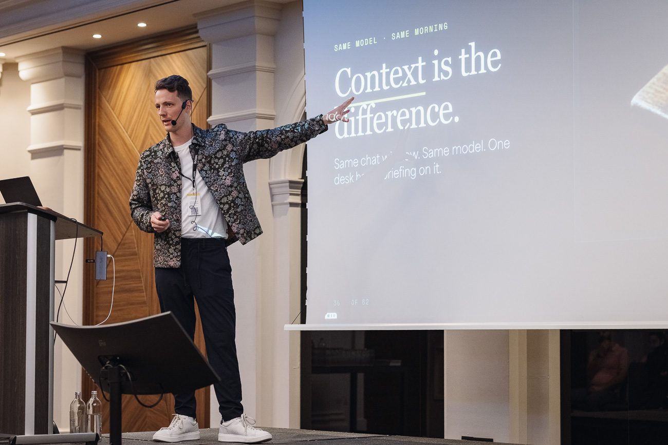 Christoph Sauerborn on stage, pointing at a slide that reads: Context is the difference.